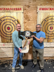 Two men with Axe throwing champion trophy